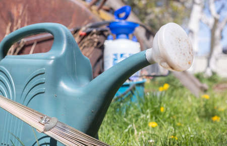 Blue plastic pot for watering in the garden. Can water. Watering can for flowers on the street, in...