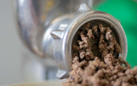 Minced meat in a manual mechanical meat grinder. Fresh boiled meat is ground with an old metal meat...