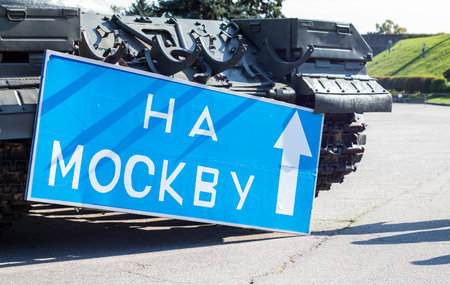 Blue road sign with white letters near the tank, on the territory of the National Museum of the...