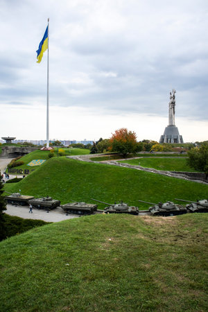 The Ukrainian flag fluttering in the wind against the blue sky, near the famous statue of the Motherland. Famous sights, monuments and monuments of Kyiv. Ukraine, Kyiv - October 08, 2022のeditorial素材