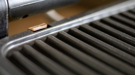 Black electric grill grate, textured background. The surface of the electric grill. Pollution of the...