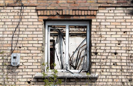 Destroyed and damaged window in the building as a result of the war. The houses were destroyed and burned by artillery during the war. Broken windows. A window destroyed by the fighting.の写真素材