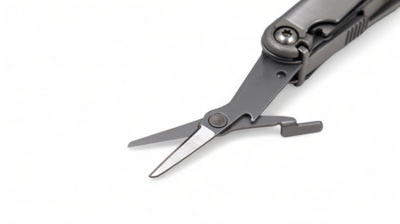 The scissors tool is pulled out of the multitool. Modern steel multitool with many tools isolated on...