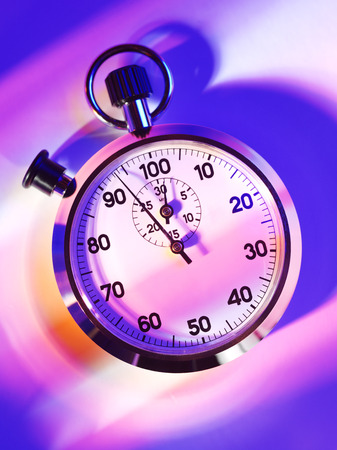 Overhead view of a sports stopwatch on a purple and pink lit backgroundの写真素材