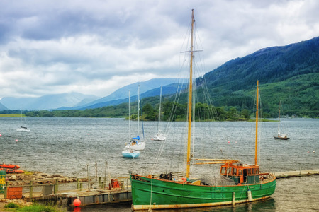 Green ship floating at the loch shoreのeditorial素材