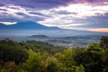 Sunrise over a valley with Borobudur temple in the distanceの写真素材