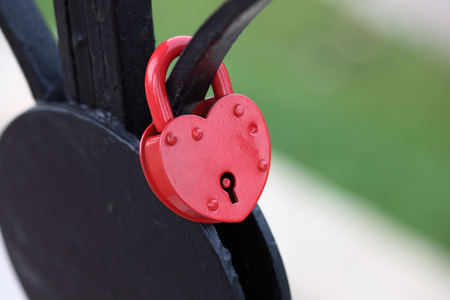 Red padlock in the shape of a heart. Shallow depth of field.の写真素材