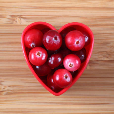 Cranberries in a heart bowl. Close-up.の写真素材