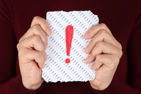 Piece of paper with red Exclamation mark in the woman's hands.の写真素材