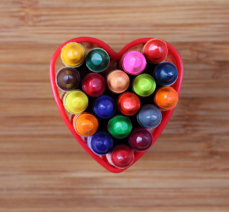 Wax crayons in a heart bowl. Close-up.の写真素材