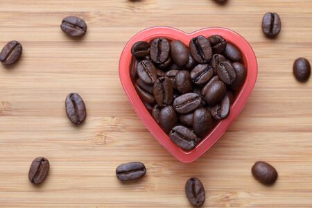 Coffee beans in a heart bowl. Close-up.の写真素材