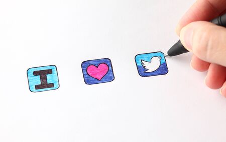 Tambov, Russian Federation - December 16, 2012 Woman's hand with ballpoint pen draw signs - I, heart and Twitter's icon. Studio shot.のeditorial素材