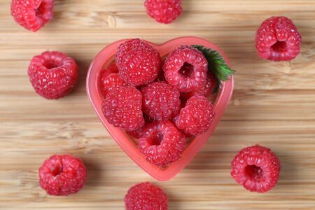 Raspberries in a heart bowl. Close-up.