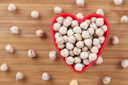 Chickpeas in a heart bowl. Close-up.の写真素材