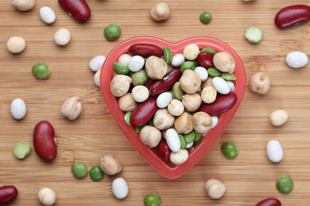Mixed legume beans in a heart bowl. Close-up.の写真素材