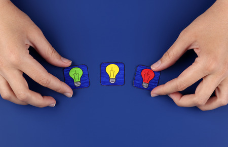 Three light bulbs on blue with woman hands. Pictures drawn by me.の写真素材