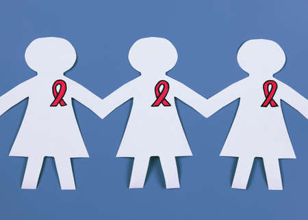 Woman paper chain with pink breast cancer awareness ribbon on a blue .の写真素材