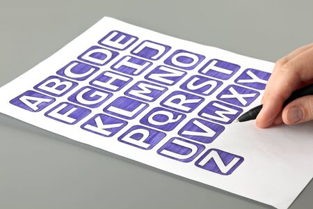 Woman\'s hand with ballpoint pen draw alphabet with letters\' blue . Letters drawn by me.の写真素材