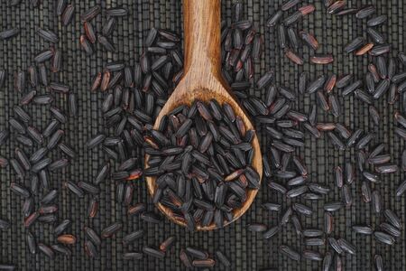 Organic Black Nerone Rice in wooden spoon on black napkin.の写真素材
