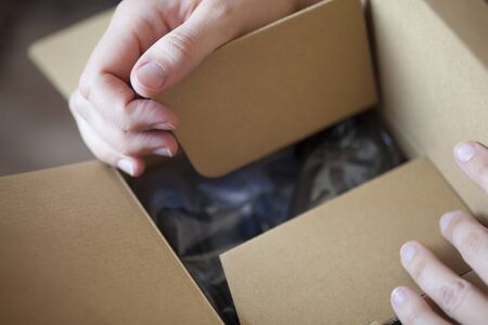 Woman's hands opening cardboard box.の写真素材