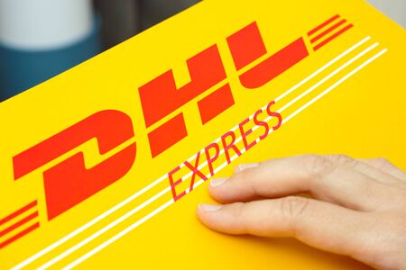 Tambov, Russian Federation - June 01, 2015 DHL Express package with human hand. Studio shot.のeditorial素材