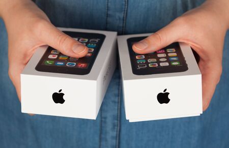Tambov, Russian Federation - January 12, 2015 Two Apple iPhone boxes in womans hands.  Studio shot.のeditorial素材