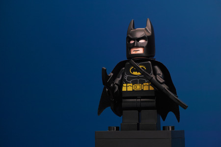 Tambov, Russian Federation - June 08, 2015 LEGO Batman minifigure with batarangs on blue background. LEGO DC Comics Super Heroes series. Studio shot.のeditorial素材
