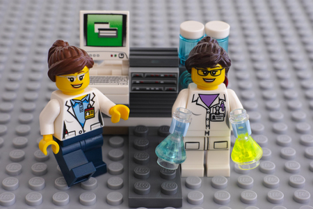 Tambov, Russian Federation - June 10, 2015 Two LEGO scientists minifigures near laboratory computer on Lego gray baseplate.のeditorial素材
