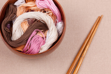 Cross-stitch threads in bowl with chopsticks.の写真素材
