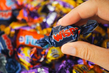 Paphos, Cyprus - November 27, 2015 Cadbury Wispa candy in womans hand with background of Cadbury...