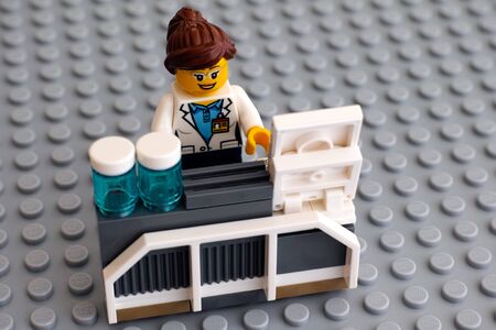 Tambov, Russian Federation - June 10, 2015 LEGO scientist minifigure on her working place with laboratory computer and bottles on Lego gray baseplate. Studio shot.のeditorial素材