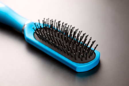 Blue hairbrush on black background.の写真素材