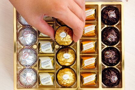 Paphos, Cyprus - November 20, 2016 Woman hand taking candy from box of Ferrero candies.のeditorial素材
