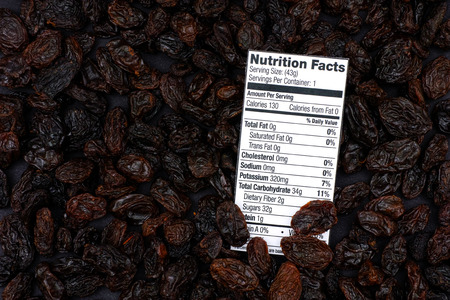 Nutrition facts of organic raisins with raisins background.の写真素材