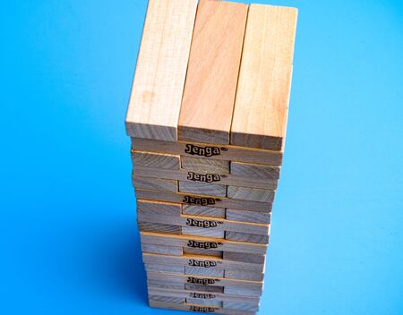 Tambov, Russian Federation - March 03, 2016 Jenga blocks in tower constructed on blue background....