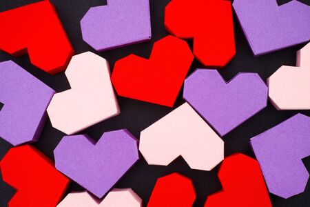 Red, purple and pink origami hearts on black backgroundの写真素材