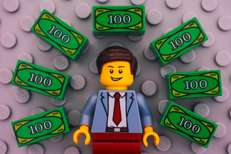 Tambov, Russian Federation - June 22, 2017 Lego businessman and Lego money on gray baseplate...