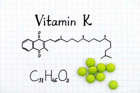 Chemical formula of Vitamin K and green pills.の写真素材