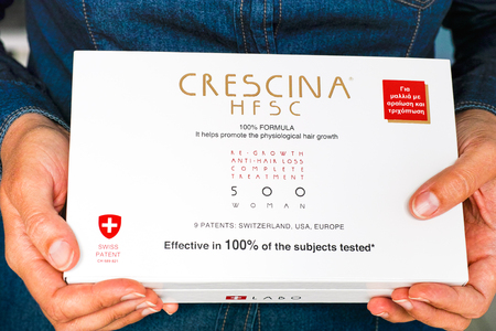 Paphos, Cyprus - November 13, 2015 Woman hands with Crescina HFSC Re-Growth Anti-Hair Loss Complete Treatment box. Crescina HFSC preserves cell longevity, fights against ageing and promotes the physiological hair growth. Made by Labo Cosprophar Suisse (Swのeditorial素材