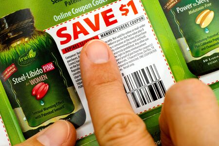 Tambov, Russian Federation - June 18, 2017 Woman fingers on Irwin Naturals discount coupon.のeditorial素材