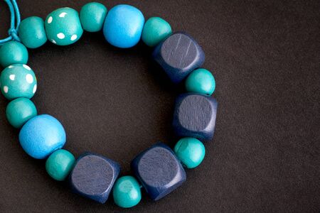 Bracelet of blue wooden beads on black background. Close-up.の写真素材