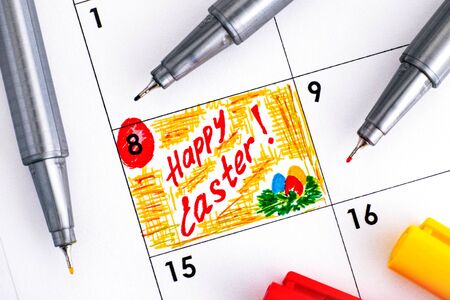 Reminder Happy Easter in calendar with coloured pens. Close-up.の写真素材