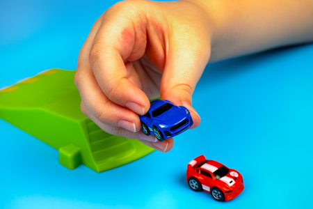 Tambov, Russian Federation - January 25, 2015 Child playing with Nano Speed Micro Cars on blue background. Studio shot.のeditorial素材