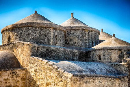 Ancient Mediterranean stone church against blue sea.