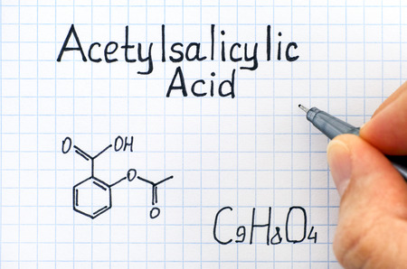 Person hand with pen writing chemical formula of Acetylsalicylic Acid. Close-up.