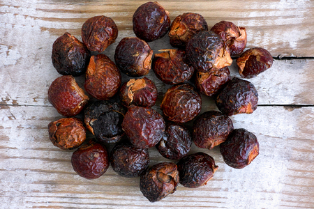 Heap of soap nuts on wooden background. Close-up.