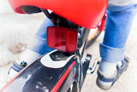 Child riding on bicycle. Close-up of rear reflector.の写真素材