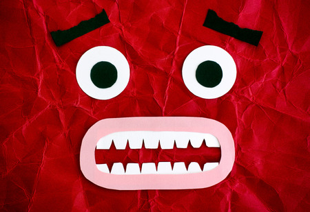 Scared character. Emotional face made from paper. Red background.