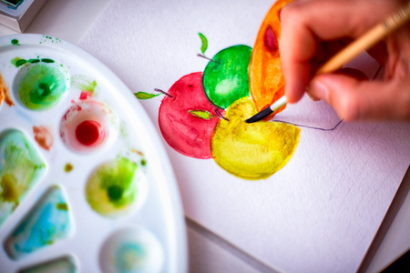 Person hand with paint brush drawing apples and pie.の写真素材