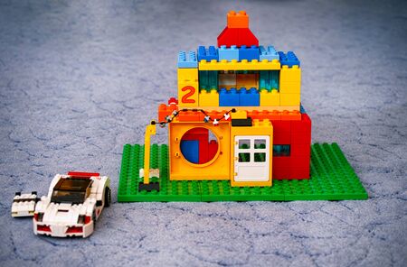 Tambov, Russian Federation - January 21, 2015 Custom made Lego Duplo house with two cars near on blue floor.のeditorial素材